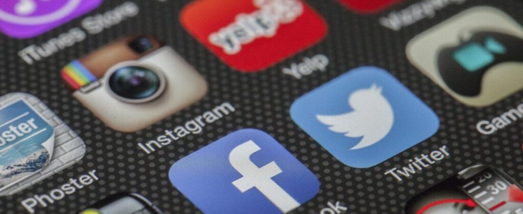 Close-up image of various social media app icons on a smartphone screen.